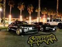 two cars parked in a parking lot at night